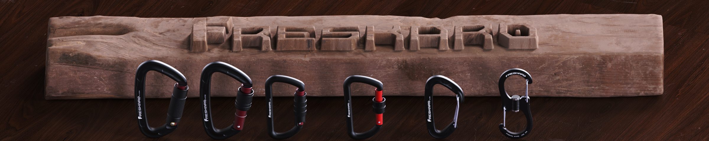 FresKaro logo carved in a walnut beam above six black carabiners